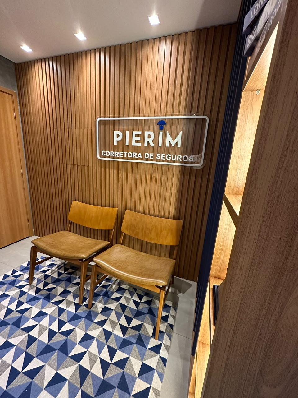 Recepção da PIERIM Corretora de Seguros com logo iluminado